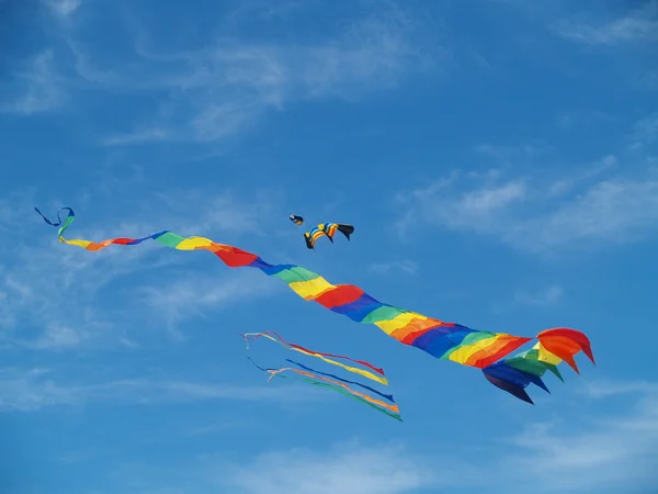 Vari aquiloni variopinti che volano in un cielo blu luminoso al festival dell'aquilone della spiaggia lunga — Foto Stock