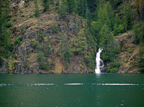 Hermosa cascada de montaña fluyendo en un lago — Foto de Stock