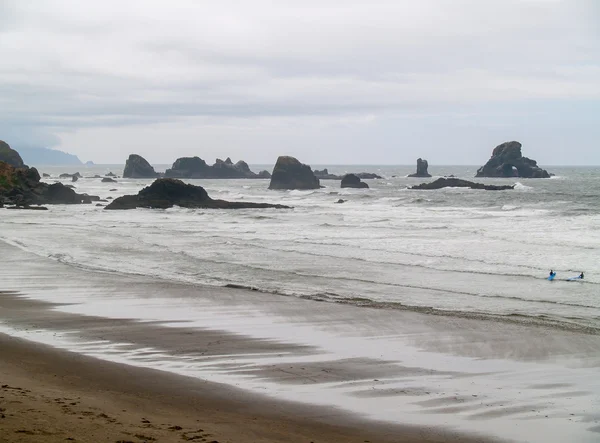 Surfeurs sur une plage rocheuse — Photo