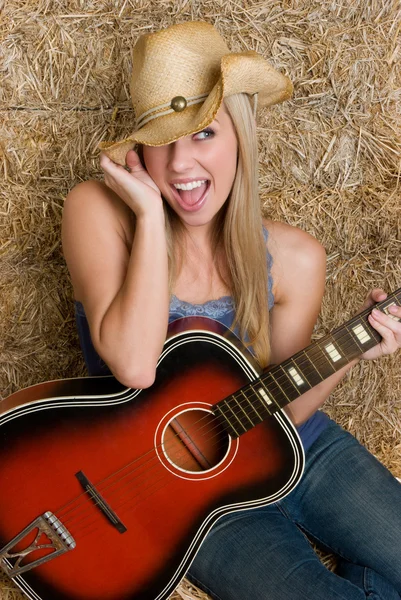 Blond cowgirl anläggning gitarr — Stockfoto