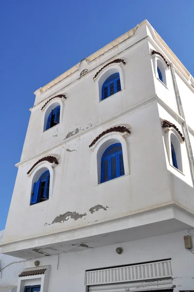 Bílý dům s modrými okny — Stock fotografie