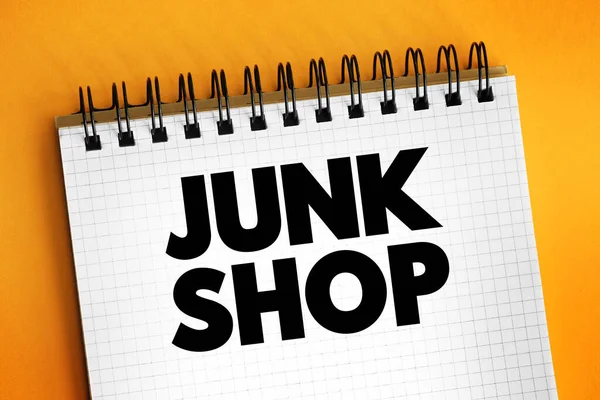 Junk shop - retail outlet similar to a thrift store which sells mostly used goods at cheap prices, text concept on notepad