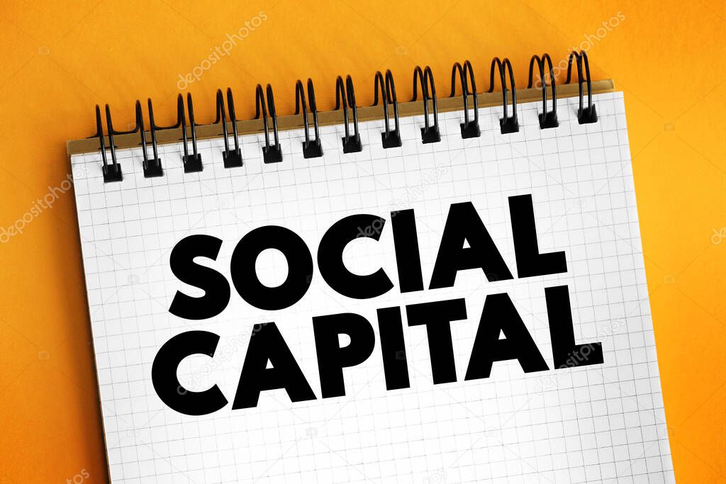 Social Capital - networks of relationships among people who live and work in a particular society, enabling that society to function effectively, text concept on notepad
