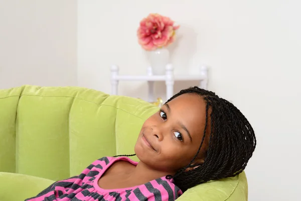 Jovem criança negra relaxante em cadeira verde — Fotografia de Stock