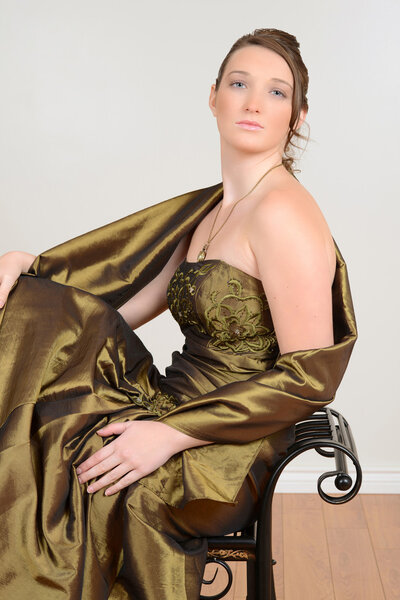 Девушка сидит на черной скамейке
