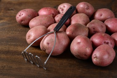 old potato masher with red potatoes clipart