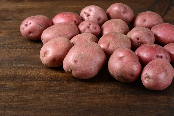 Batatas vermelhas novas em madeira — Fotografia de Stock