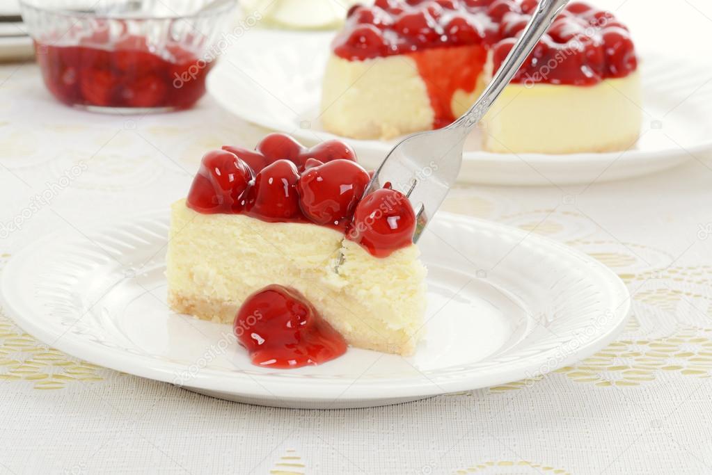 Fork cutting cherry cheesecake