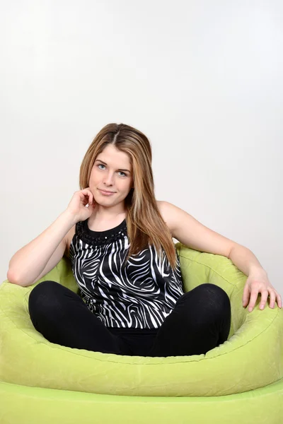 Menina adolescente relaxante na cadeira saco de feijão — Fotografia de Stock