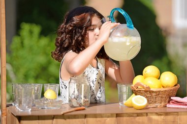 Little girl drinking from lemonade pitcher clipart