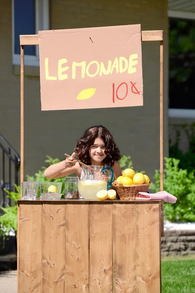 Chica joven haciendo limonada en su stand —  Fotos de Stock