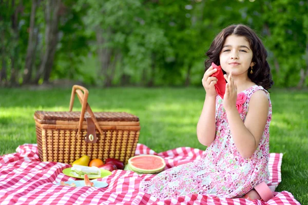女孩在野餐使用红餐巾 — 图库照片