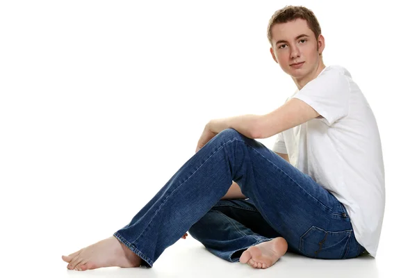 Teen boy in jeans sitting — Stock Photo, Image