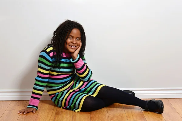 Dítě v barevné šaty sedí — Stock fotografie