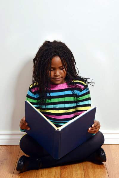 Little black girl reading book