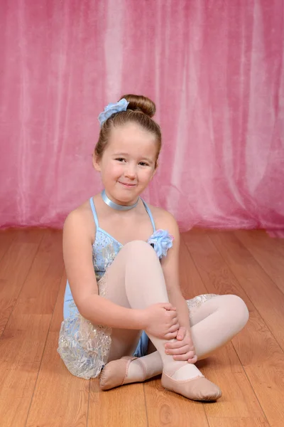 Pequena bailarina menina sentada no palco — Fotografia de Stock