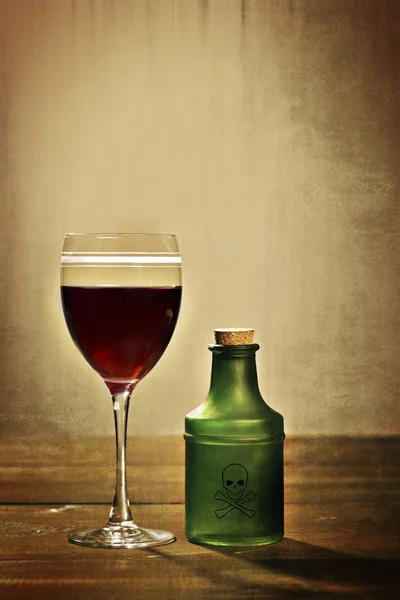 Glas rött vin med gift flaska — Stockfoto