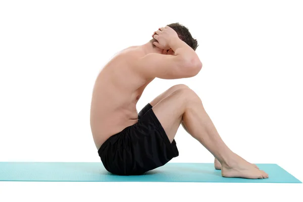 Young man doing situps on blue mat — Stock Photo, Image