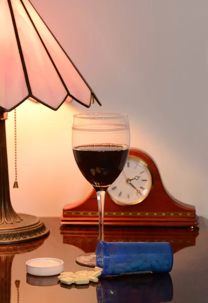 Glass red wine and spilled pills — Stock Photo, Image