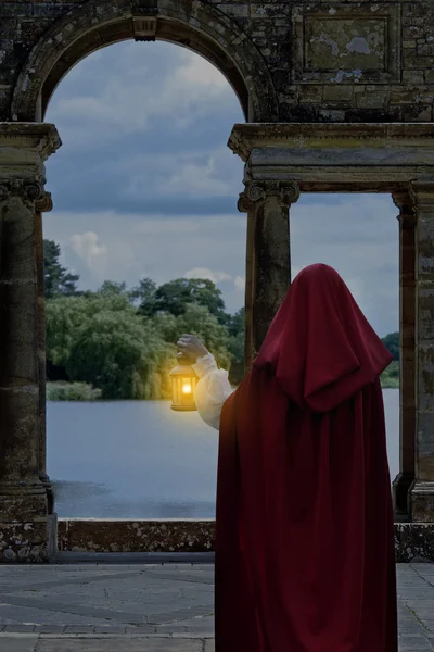 Vrouw te wachten door meer met lantaarn — Stockfoto