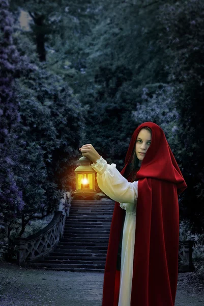 Kadın kırmızı pelerin ve fener ile — Stok fotoğraf