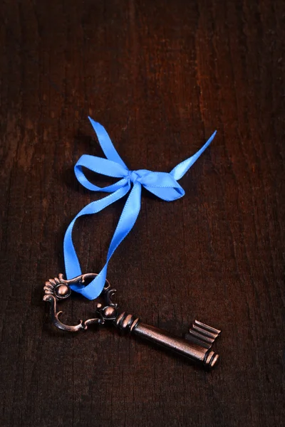 Bronze key with blue ribbon — Stock Photo, Image