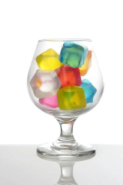 Closeup Brandy Glass Multi Colored Plastic Ice Cubes — ストック写真