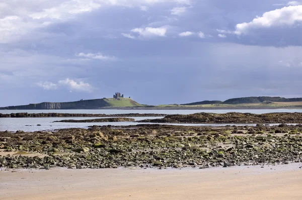 Castillo de Dunstanburgh desde la playa — Foto de Stock