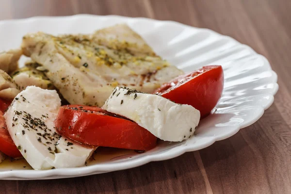 Pescado asado y ensalada de caprese italiana — Foto de Stock