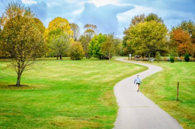 A person walking on the trail in Arboretum in Lexington, Kentucky in fall