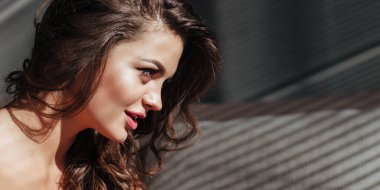 Güzel makyajlı ve seksi dudaklı esmerin baştan çıkarıcı yüzünün baner yakın çekimi. Lüks saç stili ve flörtöz görünüm.