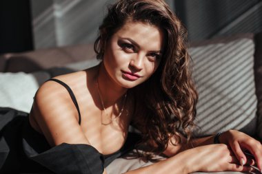 Güzel makyajlı ve seksi dudaklı esmerin baştan çıkarıcı yüzüne yakın çekim. Lüks saç stili ve flörtöz görünüm.