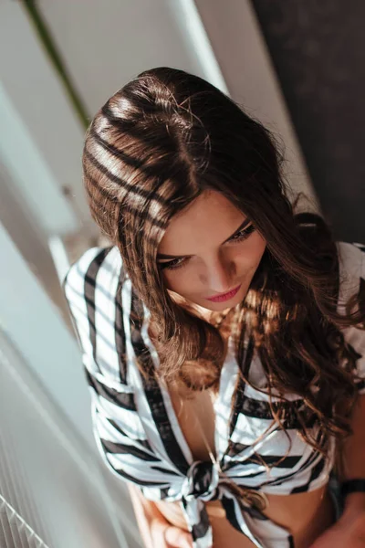 Mooie brunette vrouw met natuurlijke haren in sensuele pose op bed met open shirt en wit slipje — Stockfoto