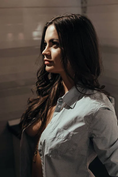 Close-up Sexy girl in a mans shirt waiting for her lover sitting in the kitchen — Stock Photo, Image