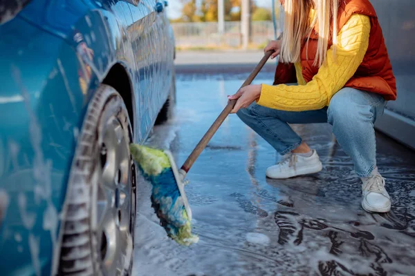 예쁜 소녀가자 가 용차 세차장에서 세차를 한다. 솔로 차에 먼지를 닦는다. — 스톡 사진