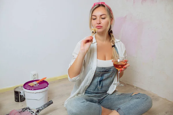 Sexy chica diseñadora come sushi en el sitio de construcción. pintor tiene almuerzo después del trabajo.Concepto de diseño de interiores y reparación de habitaciones — Foto de Stock