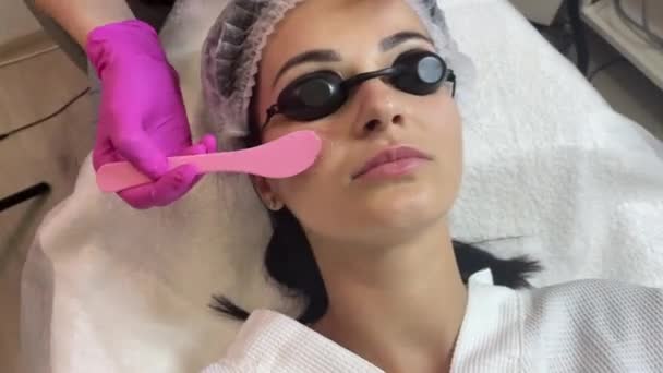 Le médecin cosmétologue applique un gel sur le patient pour la procédure des smas liftig peau. Rajeunissement facial au laser — Video