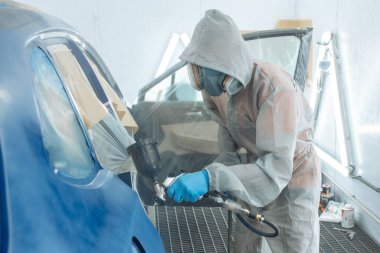 Otomobil tamircisi ressam elinde araba vücut boya odasında boyama airbrush Montaj cihazları-Pulverizatör ile koruyucu eldiven.