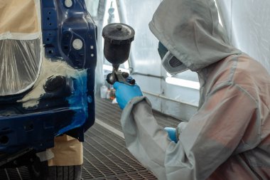 Otomobil tamircisi ressam elinde araba vücut boya odasında boyama airbrush Montaj cihazları-Pulverizatör ile koruyucu eldiven.