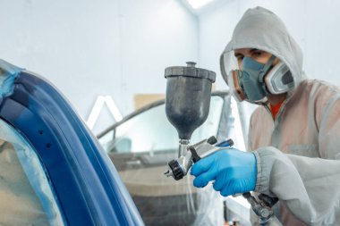 Otomobil tamircisi ressam elinde araba vücut boya odasında boyama airbrush Montaj cihazları-Pulverizatör ile koruyucu eldiven.