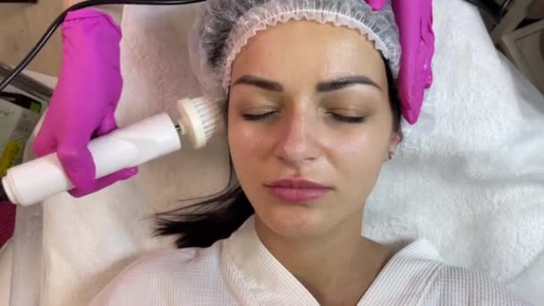 Escovar a pele. O dprmatologista e cosmetologista faz o peeling facial com a ajuda da escovação. Spa Cosmetologia — Vídeo de Stock