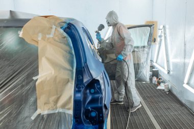 Otomobil tamircisi ressam elinde araba vücut boya odasında boyama airbrush Montaj cihazları-Pulverizatör ile koruyucu eldiven.