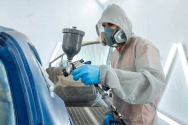 Otomobil tamircisi ressam elinde araba vücut boya odasında boyama airbrush Montaj cihazları-Pulverizatör ile koruyucu eldiven.