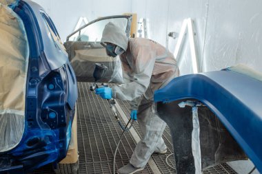 Otomobil tamircisi ressam elinde araba vücut boya odasında boyama airbrush Montaj cihazları-Pulverizatör ile koruyucu eldiven.