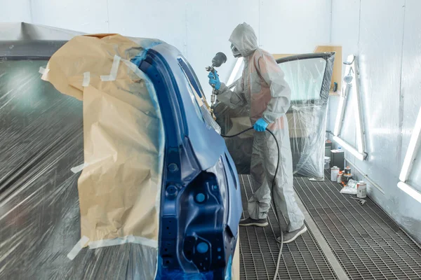 Otomobil tamircisi ressam elinde araba vücut boya odasında boyama airbrush Montaj cihazları-Pulverizatör ile koruyucu eldiven.