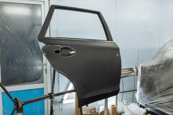 Reparador de automóviles pintor mano en guante protector con pulverizador de aerografo pintura carrocería del coche en la cámara de pintura . — Foto de Stock