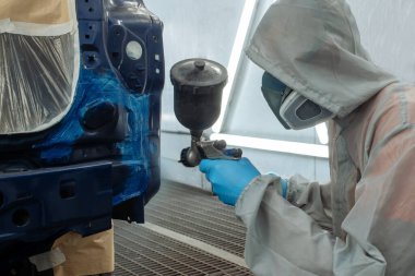 Otomobil tamircisi ressam elinde araba vücut boya odasında boyama airbrush Montaj cihazları-Pulverizatör ile koruyucu eldiven.