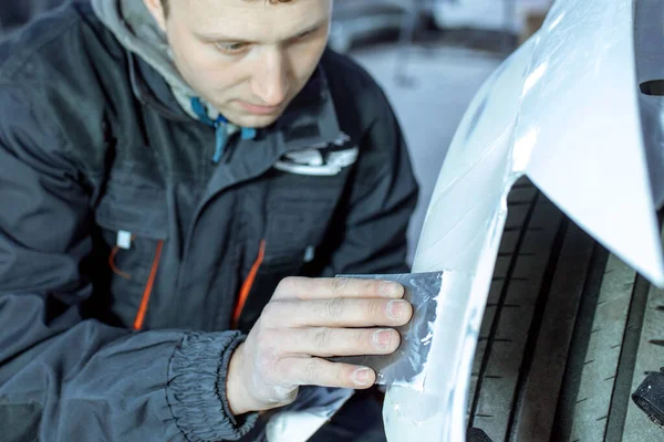 Reparação do corpo do carro, colocando fechar o trabalho após o acidente, trabalhando lixar primer antes de pintar. , O mecânico reparar o carro, Usando massa de vidraceiro de plástico, Prepare a superfície para pintura por pulverização. — Fotografia de Stock