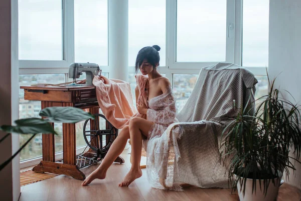Sexy Dziewczyna Białej Przezroczystej Tuniki Siedzi Szycie Pobliżu Okna Piękne — Zdjęcie stockowe