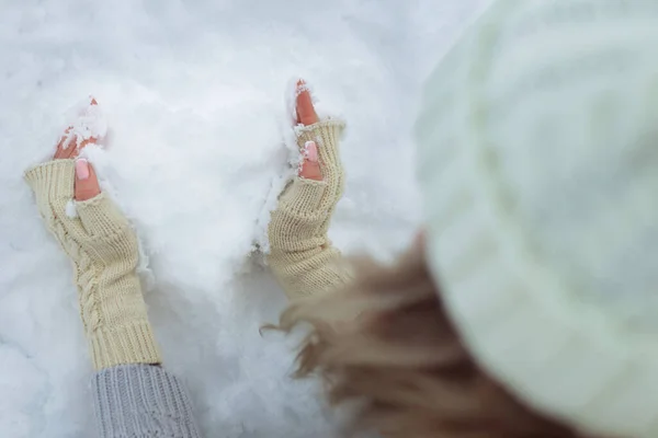 Primo piano Cuore di neve in mani in guanti lavorati a maglia sullo sfondo di copertura di neve. San Valentino — Foto Stock